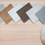 An example of a catalog of luxury vinyl floor tiles and a designer palette with textures with a new interior design for a house or floor on a light wooden background.